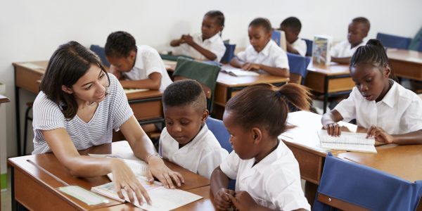 volunteer-teacher-helping-school-kids-at-their-desks.jpg